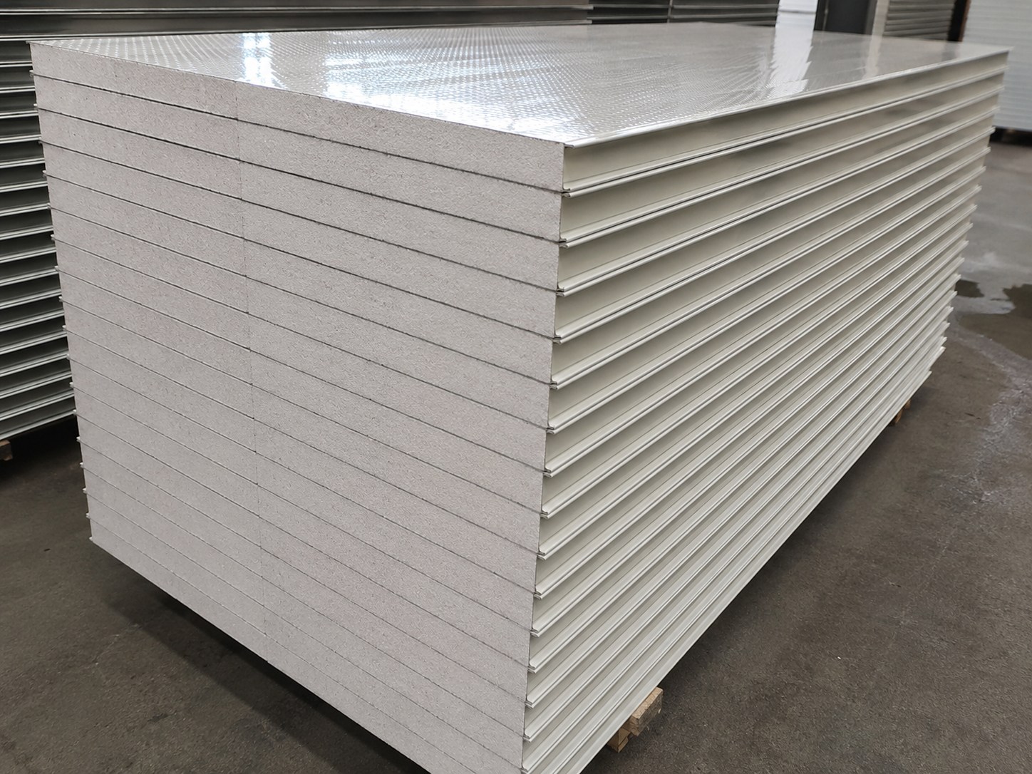 Stack of white EPS coolroom panels showing the insulated core and profiled steel faces